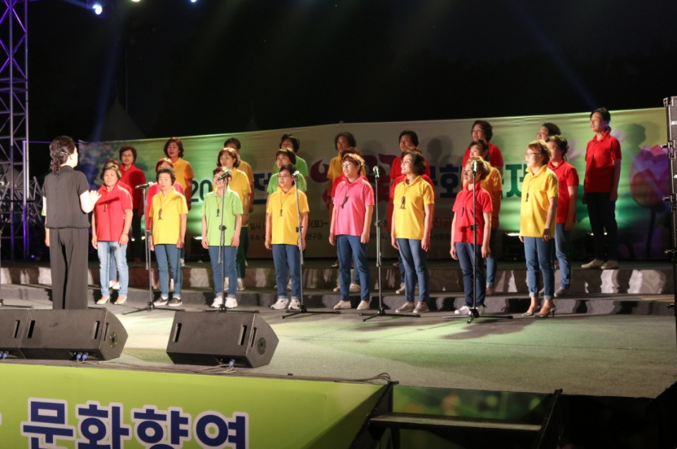 연꽃합창제에 참가한 김제보리수합창단원들이 형형색색의 단복을 입고 밤하늘을 울리는 노래를 하고 있다.