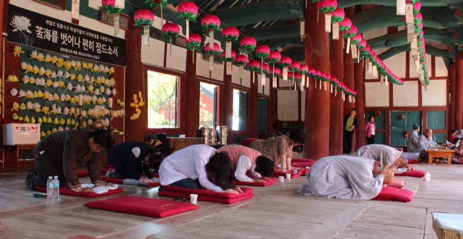 고창군종합사회복지시설 직원들이 지난 5월 부처님오신날을 맞아 선운사 만세루에서 스님들의 지도를 받아 절 기도를 하고 있다.