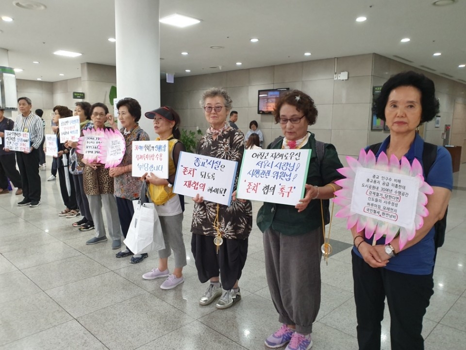 지난 18일 서울시가 개최한 '2030 공원녹지 기본계획 일부정비(안) 공청회’에서 "참나선원의 존치를 바란다"는 피켓 시위를 하고 있는 참나선원 신도들의 모습.