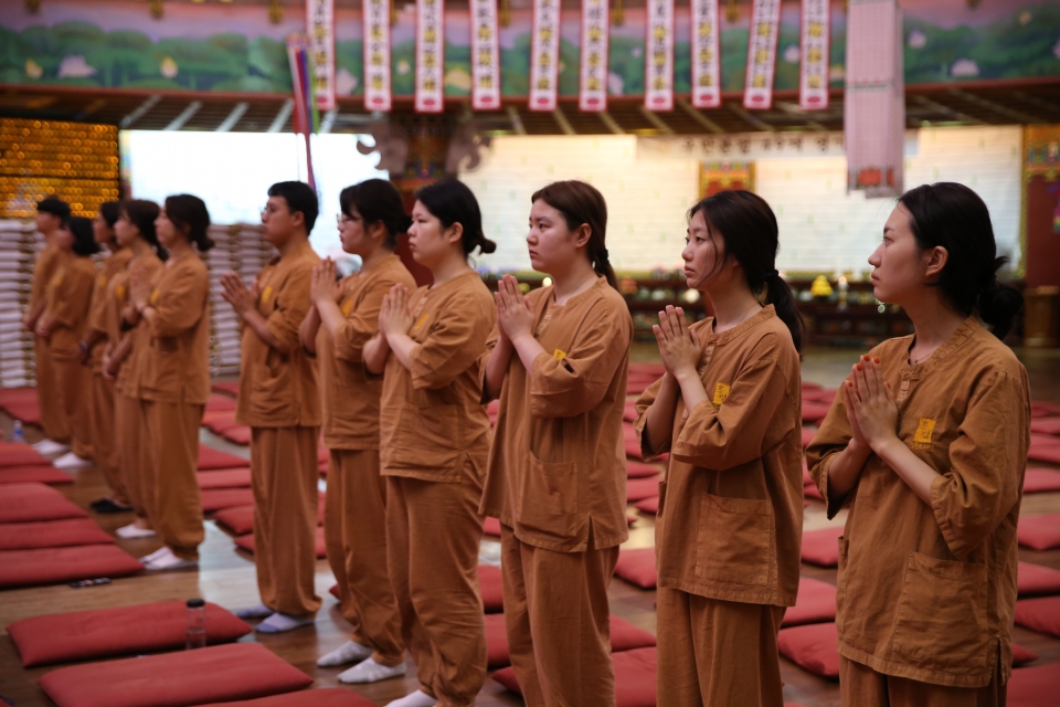 템플스테이 참가 청년들이 합장 등 불교 예절을 배우는 모습.