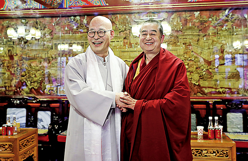 한국불교언론사 대표단장 진우스님(왼쪽)과 타얼사 관리위원회 주임 얀시우 스님이 악수를 나누며 웃고 있다.