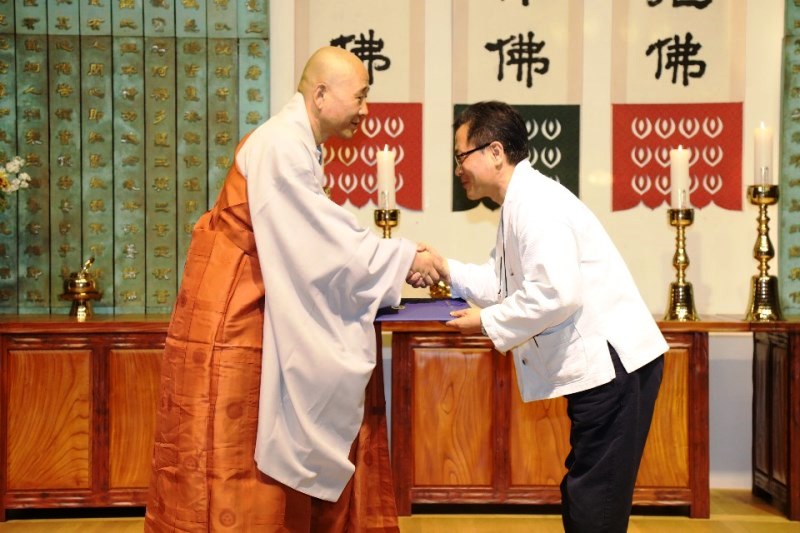 박종안 씨가 우수상인 정호스님으로부터 불교신문 사장상 받고 있다.