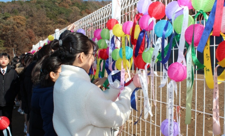 상월선원 철조망에 소원등을 거는 동대부여중 학생들.
