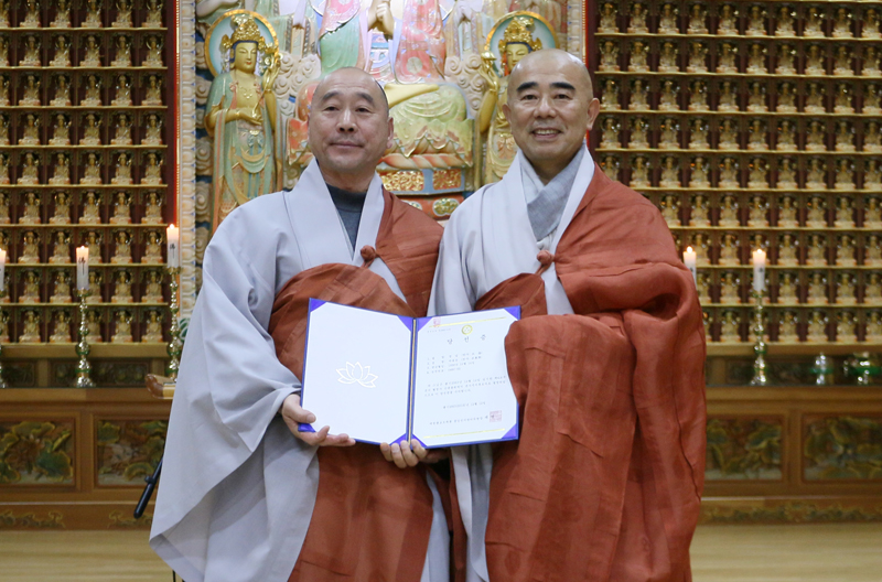 중앙선거관리위원장 세영스님에게 당선증을 받는 정념스님(왼쪽)