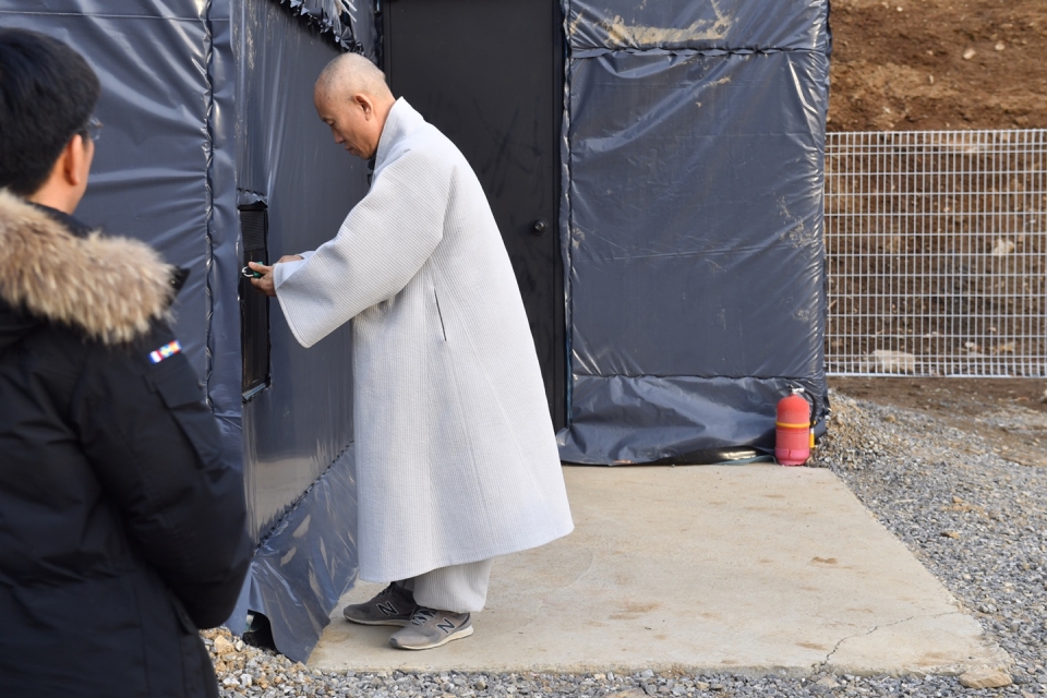 9명 정진대중 스님들의 7일 용맹정진을 하루 앞둔 1월29일 오후, 상월선원 배식구로 장군죽비가 들어가고 있다.