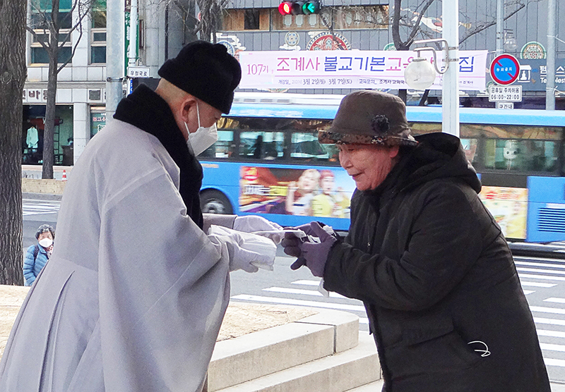전 세계가 신종 코로나 바이러스 예방대책에 부심하고 있는 가운데 서울 조계사는 2월4일 일주문 앞에서 입춘기도를 맞아 조계사를 찾는 신도들에게 마스크를 배부했다. 사진은 주지 지현스님이 마스크를 나눠주는 모습.