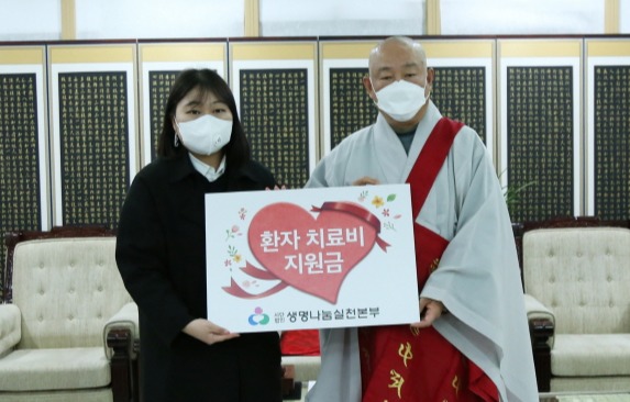 생명나눔 이사 호명스님 3월 치료비 지원 환자 김새봄 양을 대신해 참석한 이수진 사회복지사에게 치료비를 전달하는 모습.