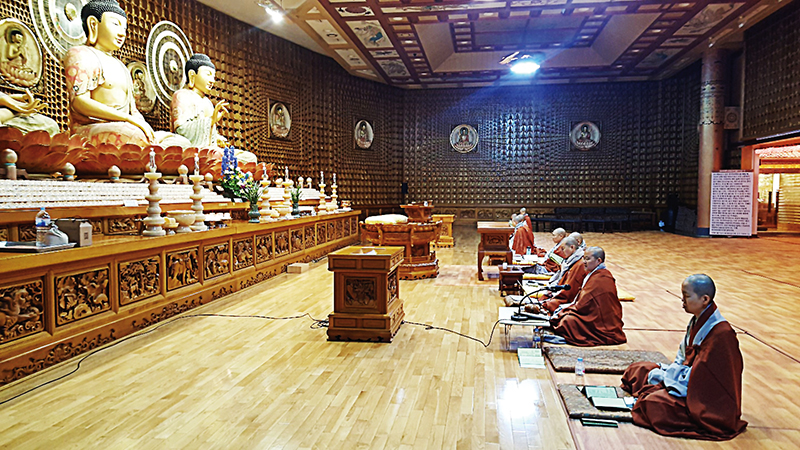 코로나19로 인한 사회적 거리두기로 신도 없는 법당에서 스님들이 기도하는 모습.