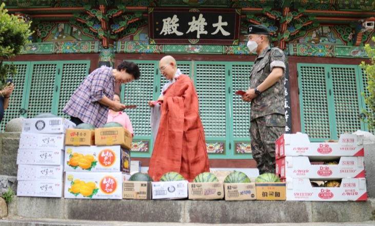 공해스님이 김제보리수합창단 유옥선 단장에게 격려금을 전달하고 있다.