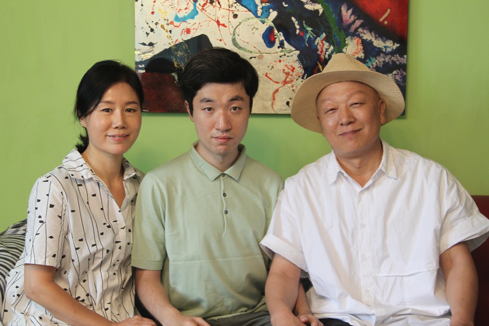 ‘피아노 병창’이라는 새로운 장르를 창시하고 감각적인 작곡능력을 뽐내고 있는 예술가 최준을 만났다. 그의 부모와 함께 사진을 찍는 최준 군(사진 가운데).