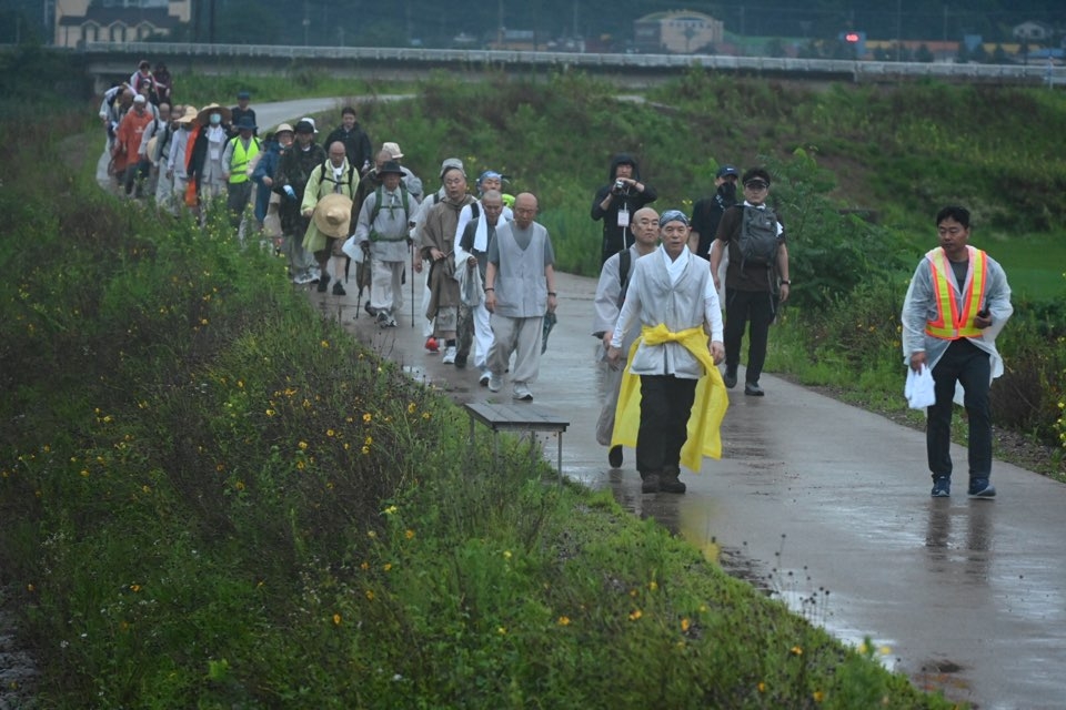 상월선원 인도만행결사 공주예비순례에 동참한 대중들이 둑방길을 걷고 있다. 김형주 기자