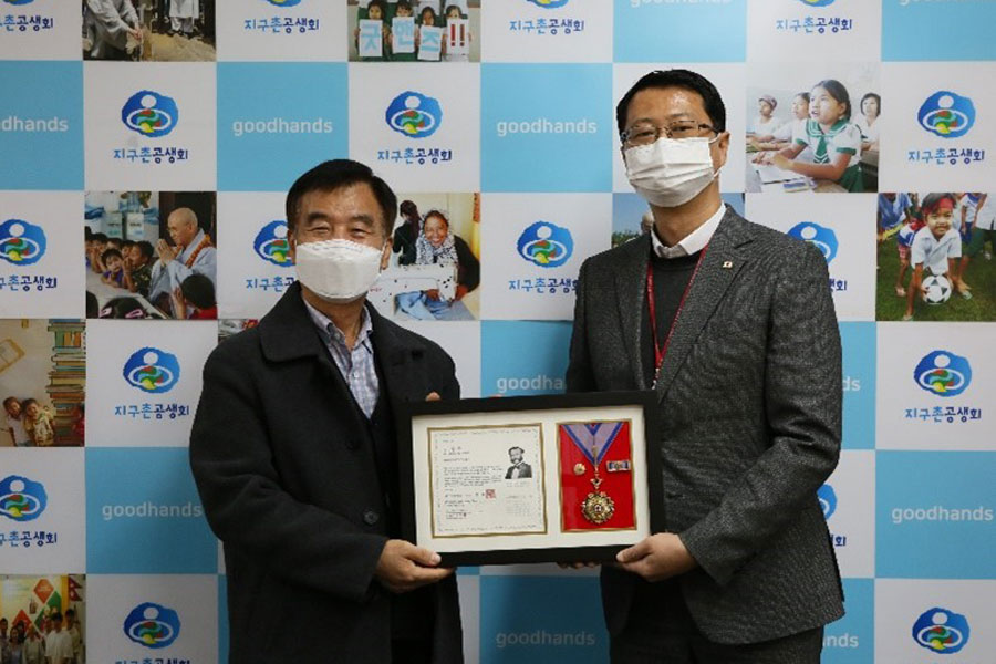김영하 지구촌공생회 사무국장(왼쪽)이 대한적십자사에서 수여하는 '적십자회원유공장 최고명예장'을 받고 있다.