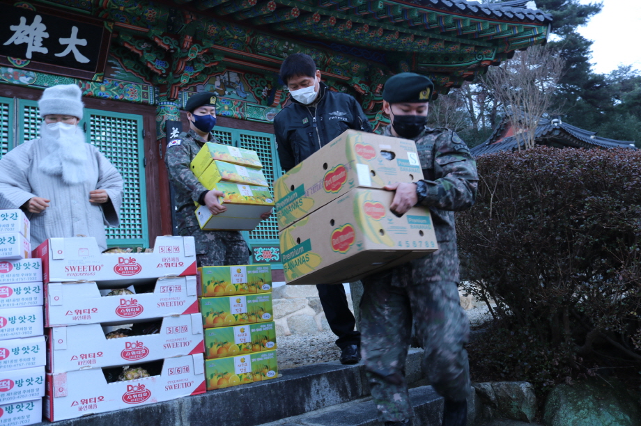 병사들이 위문품을 차로 옮기고 있다.