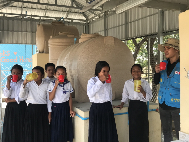 지구촌공생회가 캄보디아 앙닐 법운화중고등학교에 건립한 식수대에서 현지 학생들이 물을 마시고 있는 모습.