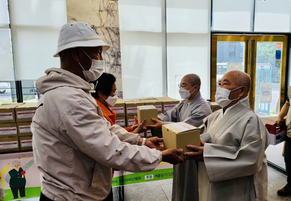 동원사 회주 지각스님(사진 오른쪽부터)과 주지 지장스님이 지역 어르신들에게 행복선물세트를 전달했다