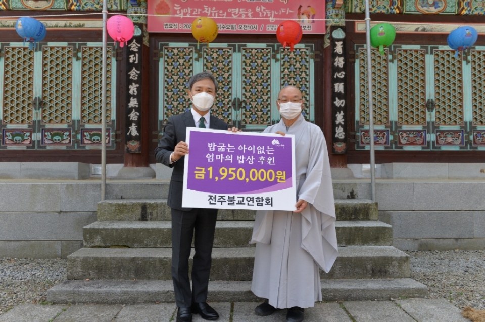 전주불교연합회 공동대표 덕산스님이 김승수 전주시장에게 성금을 기탁하고 있다.