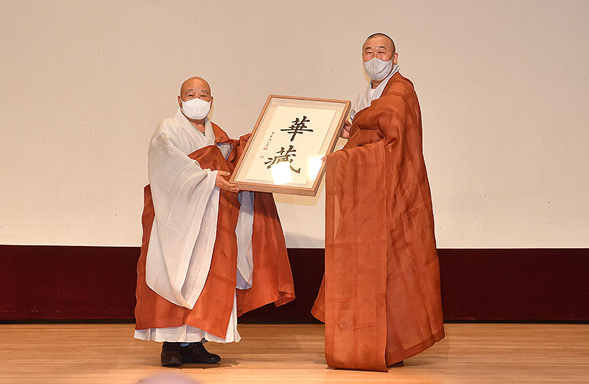 화엄사 주지 덕문스님이 총무원장 원행스님에게 기념 글씨를 선물하고 있다.