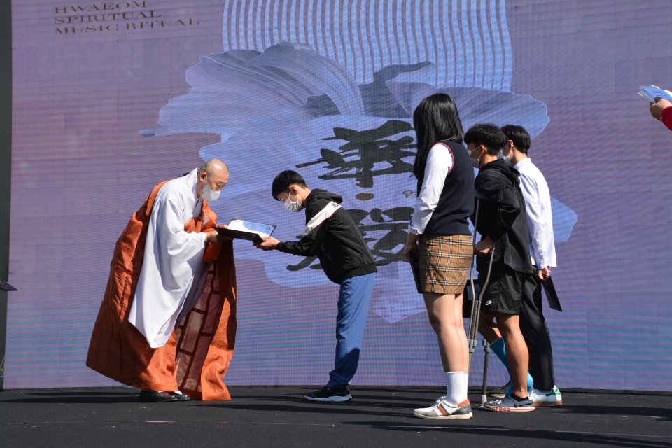 화엄사 주지 덕문스님이 걷기대회에 앞서 지역 청소년들에게 장학금을 전달하고있다