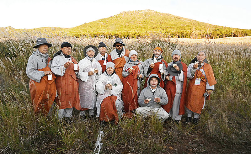 10월17일 새벽5시 표충사를 출발한 순례단이 일출 직전에 재약산 사자평에 다다랐다. 추위에 떨며 아침 공양을 하던 중 표충사 주지 진각스님이 지게를 지고 따뜻환 찐빵을 가지고 오자 회주 자승스님과 1조 스님들이 진빵을 먹으며 기념촬영을 했다. 밀양=김형주 기자 cooljoo@ibulgyo.com