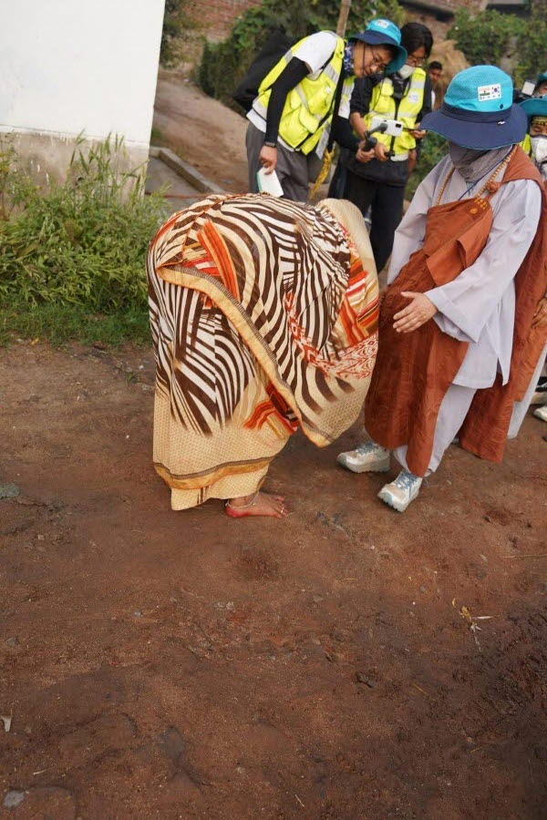 ​몸을 숙여 스님 발에 손을 대고 예를 표하는 인도 불자.​