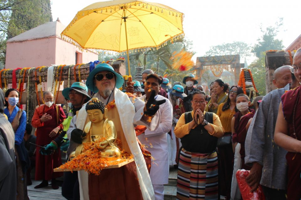 상월결사 회주 자승스님이 마하보디사에서 불상을 이운하며 대중에게 꽃비를 뿌리고 있다.