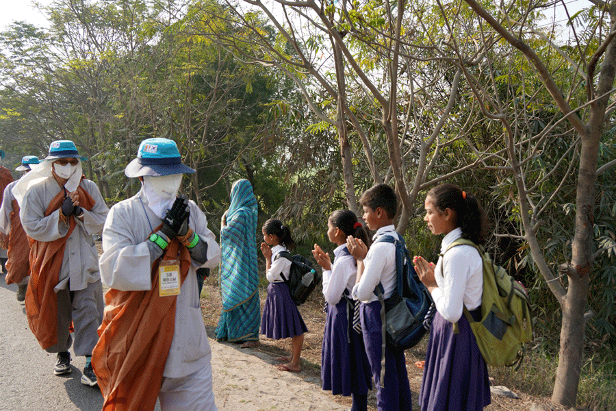순례단을 지켜보는 인도 학생에게 합장으로 인사하고 있다.