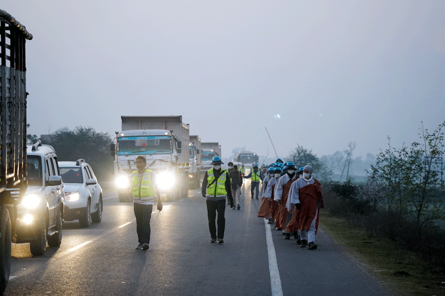 어스름한 새벽, 즐비한 차량의 운행으로 위험을 감수하며 걷는 순례단.