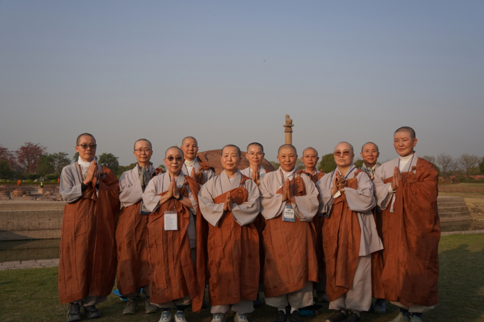 아쇼카 석주를 배경으로 선 비구니 스님들.