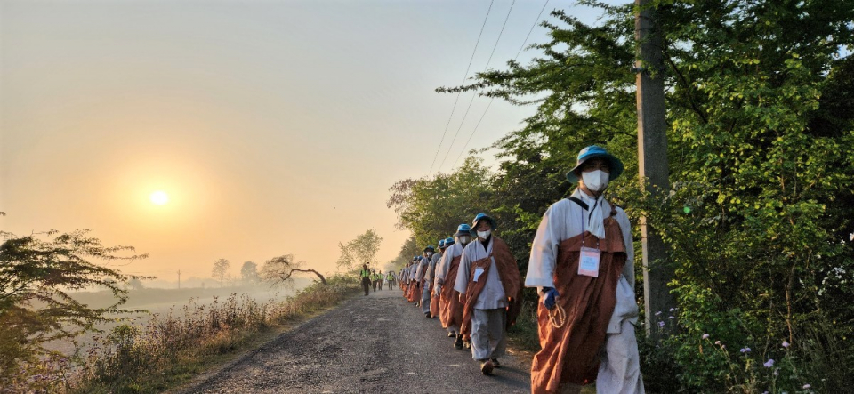 강을 따라 쿠시나가르로 향하는 순례단 등 뒤로 해가 떠오르고 있다.