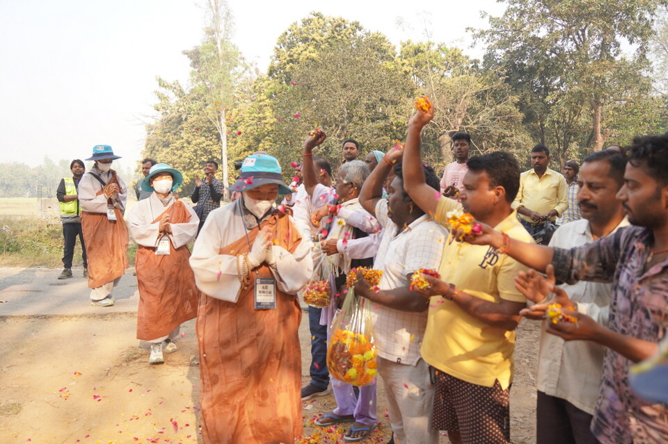 숙영지 입구에서 꽃을 뿌리며 환영하는 주민들