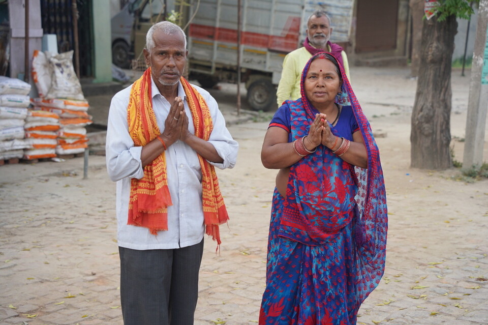 순례단을 보고 합장하는 노부부.