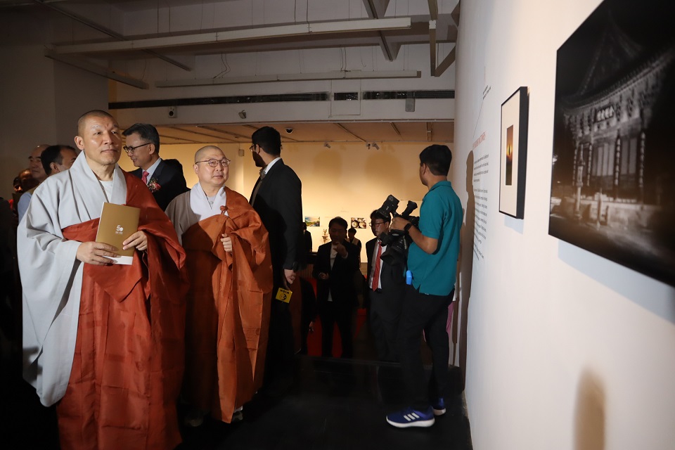 종회의장 주경스님과 사회부장 범종스님이 내빈들과 함께 사진을 보고 있다. 