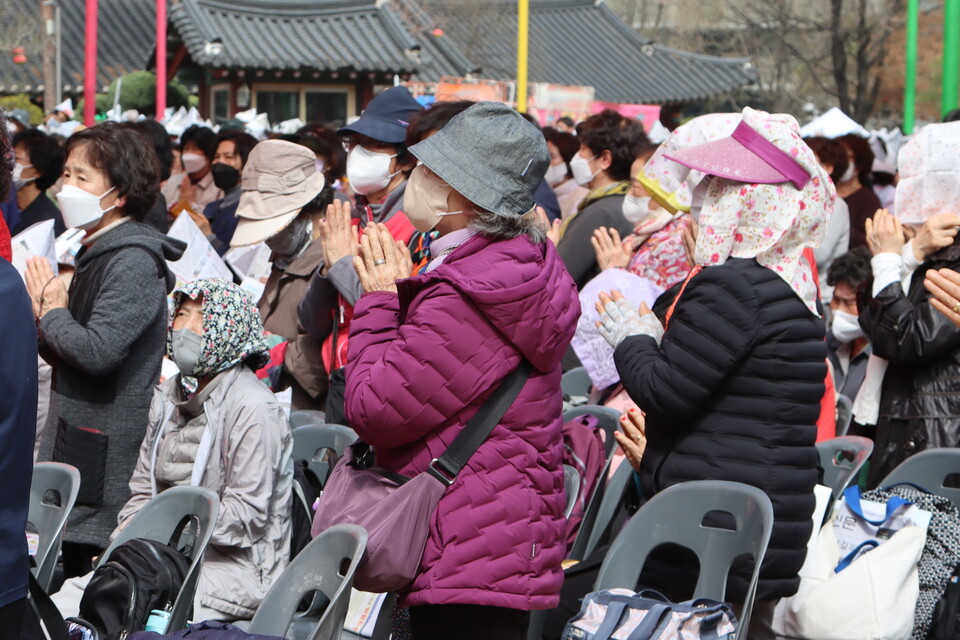 스크린으로 상월108원력문을 보며 합장하고 있는 신도들의 모습이다.
