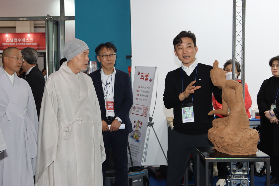 회주 자승스님이 관계자에게 작품 설명을 듣고 있다.