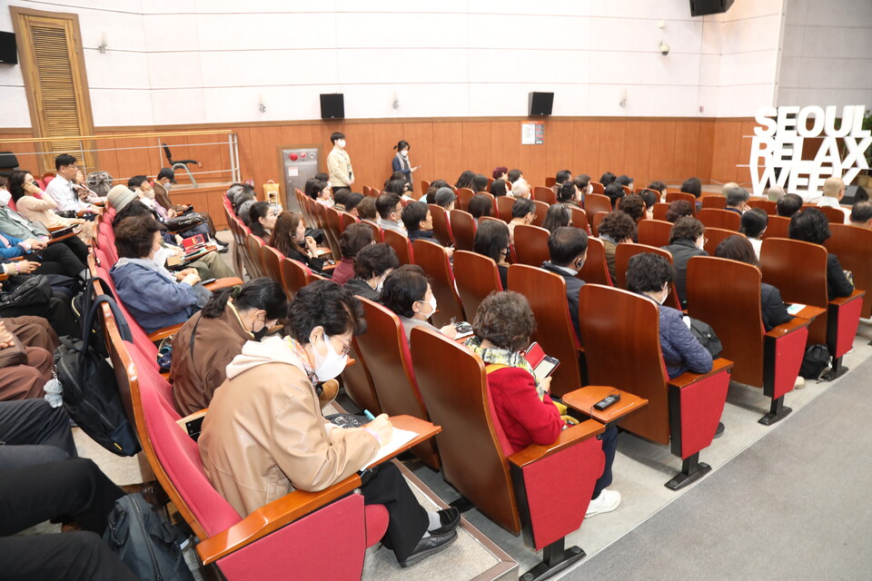 필기를 하며 강연을 듣는 참가자.