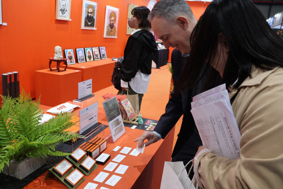 경전 구절이 담긴 카드를 고르고 있는 국제이구기구 스티븐 해밀턴 씨. 통역사에게 해석을 요청했다.