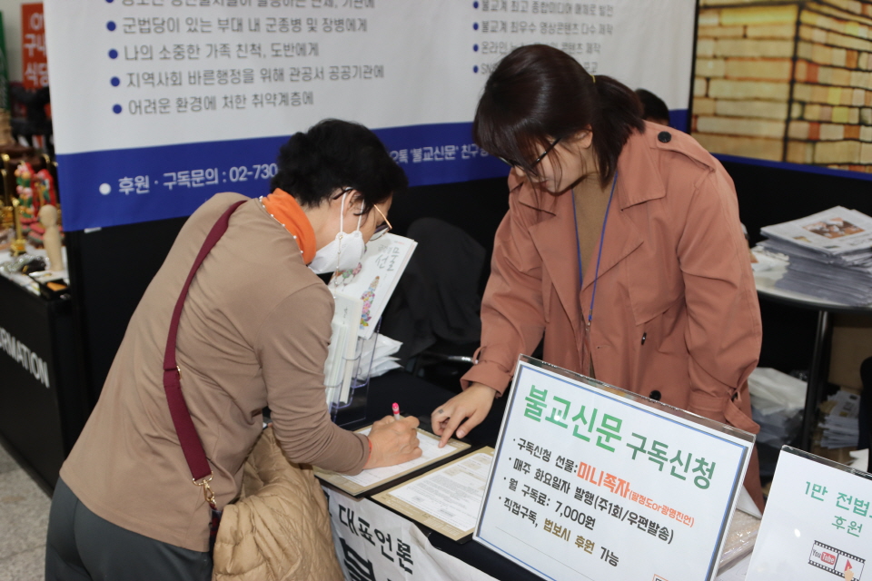 박람회장 1층 로비에 위치한 불교신문 홍보부스에서 한 불자가 불교신문 법보시를 신청했다.
