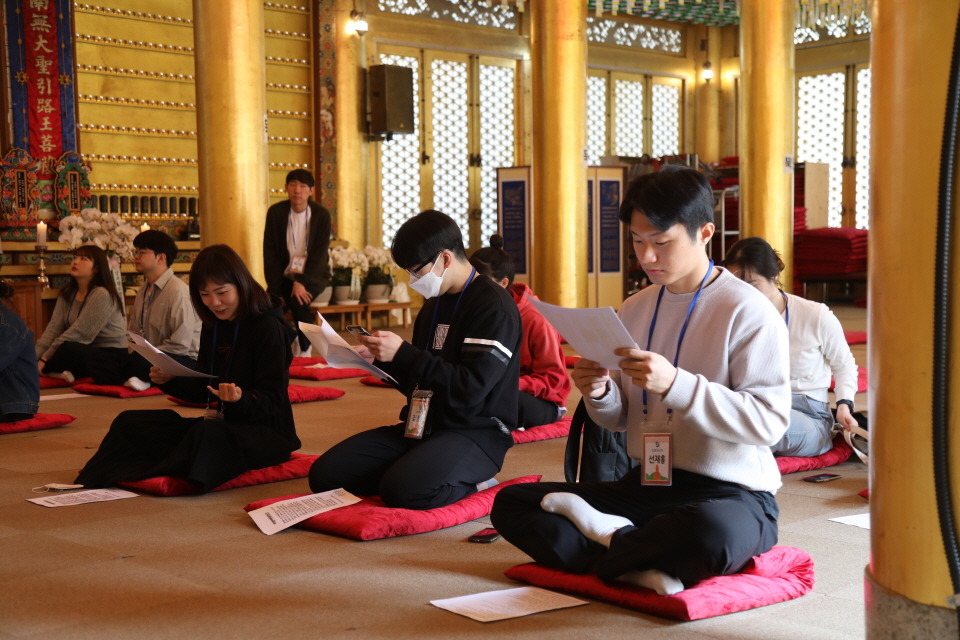 입재식 전 한글 반야심경과 상월청년회 4기 활동계획이 적힌 유인물을 유심히 살피는 신입회원들.