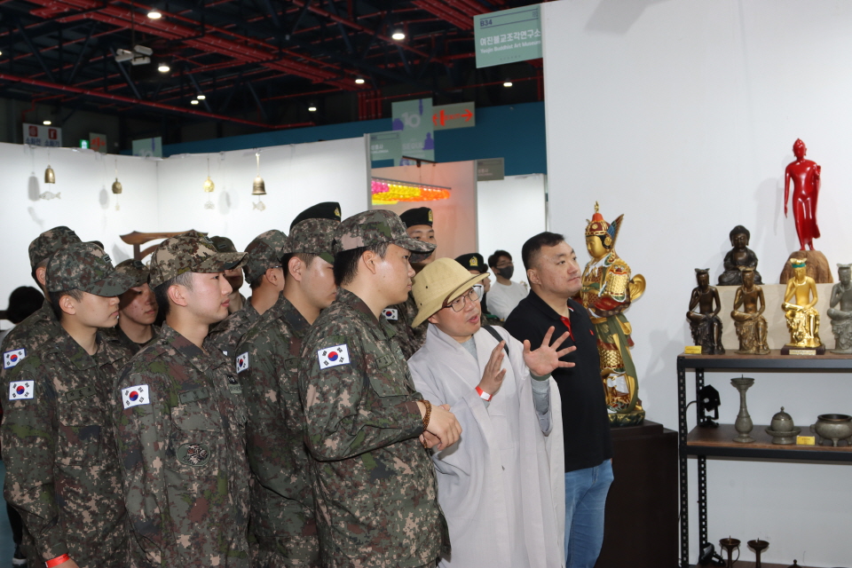 육군 제56보병사단 호국백운사 주지 도원스님이 '여진불교조각연구소' 부스에서 군장병에게 불상을 설명하고 있다. 