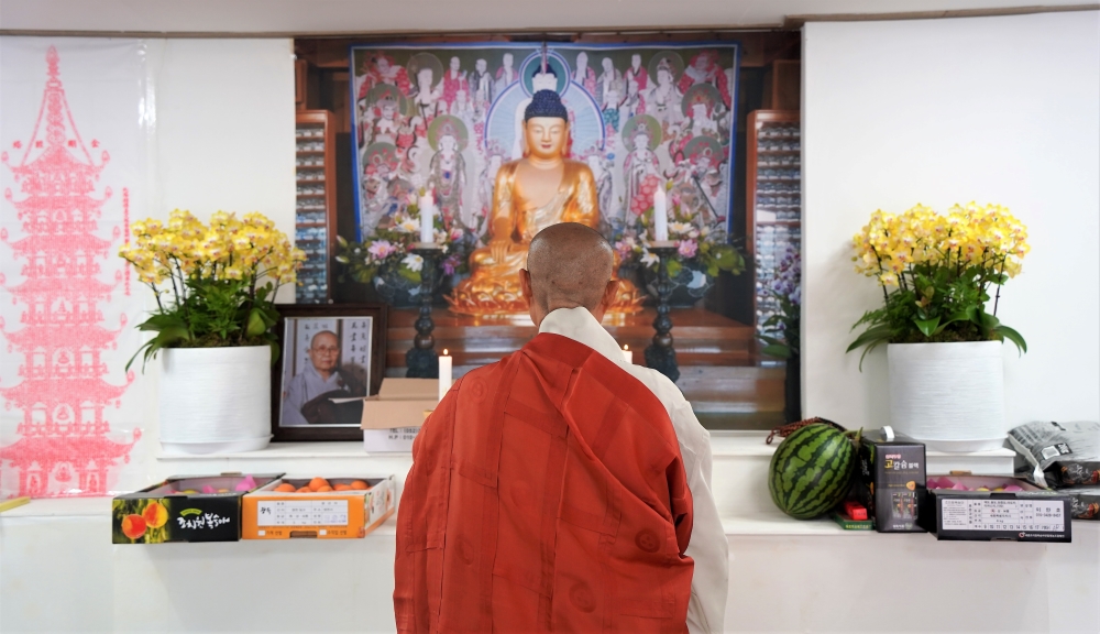 임시법당에서 목윤스님이 기도하고 있다. 부처님도 화마가 휩쓸고 가 사진으로 대신했다.