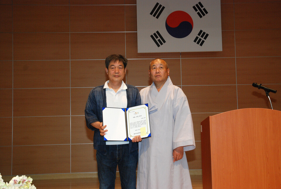 신태수 화백에게 자료 수증 증서를 수여한 최치원문학관장 정우스님.