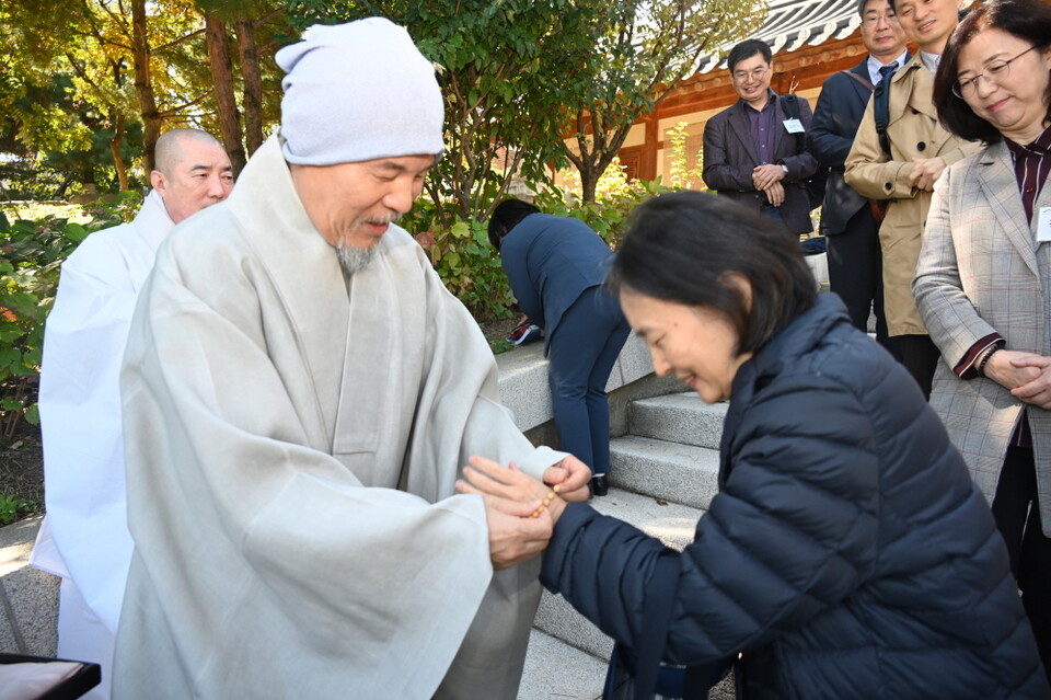 회주 스님이 교수 불자들에게 단주를 선물하고 있다.