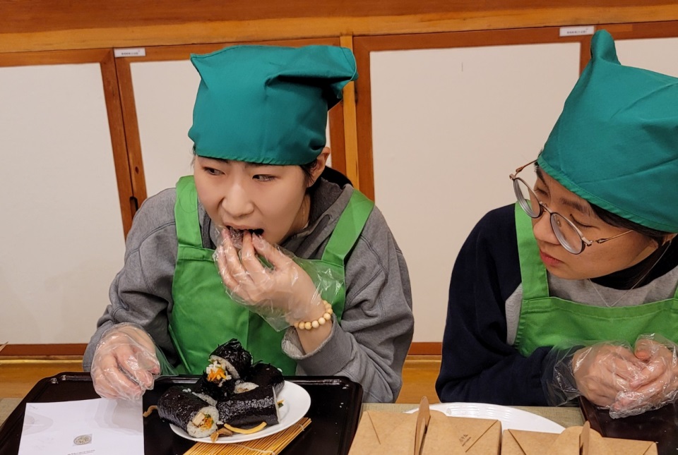 먹음직스럽게 김밥을 썰어 맛보는 수험생.