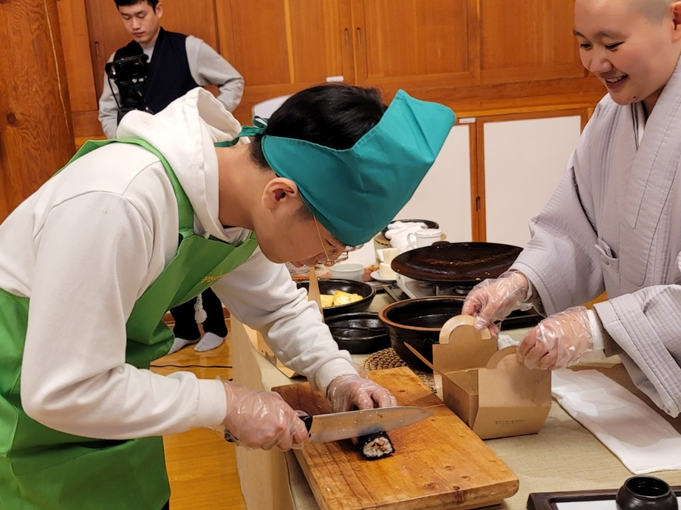 김밥썰기가 가장 아이들에게 난이도가 높았다. 스님 앞에서 지도받는 남학생.