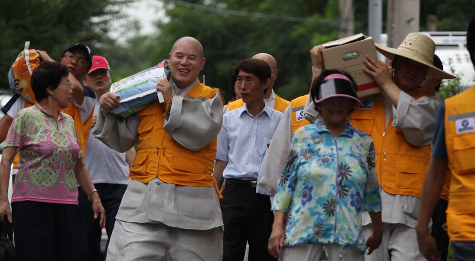 2011년 7월 백사마을에서 기초수급자 어르신들을 위해 쌀 포대를 나르는 모습.