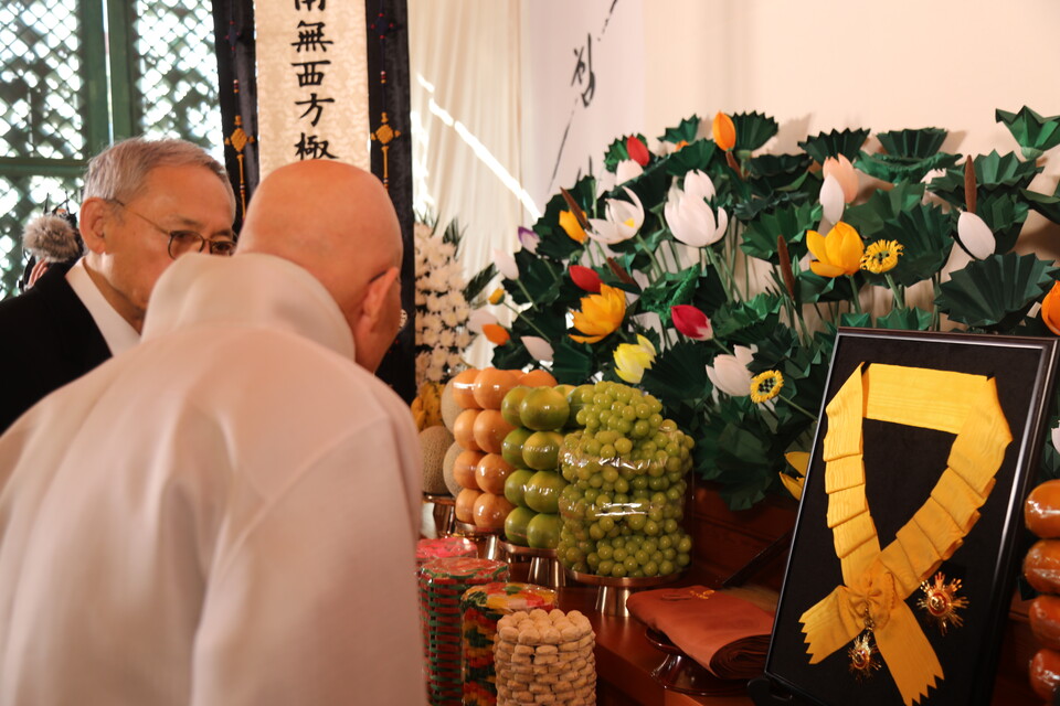 자승대종사에게 추서된 국민훈장 무궁화장을 함께 보고 있는 총무원장 진우스님과 유인촌 장관.