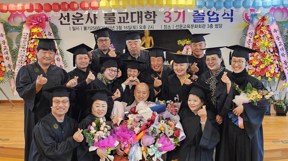 졸업생들이 학감 혜수스님과 함께 기념촬영을 하고 있다.