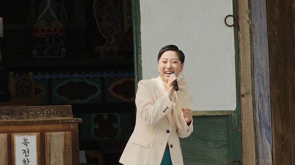 트롯가수 조계사 홍보대사 목비 가수가 흥겨운 노래와 율동을 보여주고 있다.