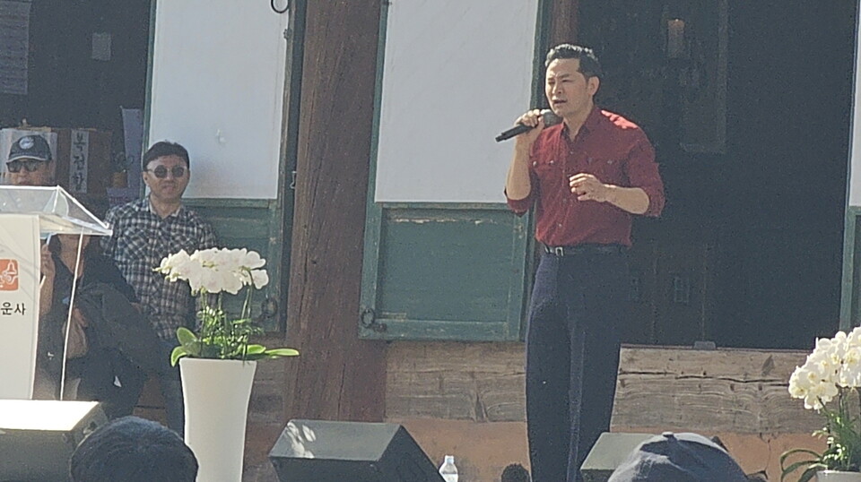 인가 소통 강사 김창옥 교수가 단상에 올라 특유의 활발한 제스처를 쓰며 강연을 하고 있다.