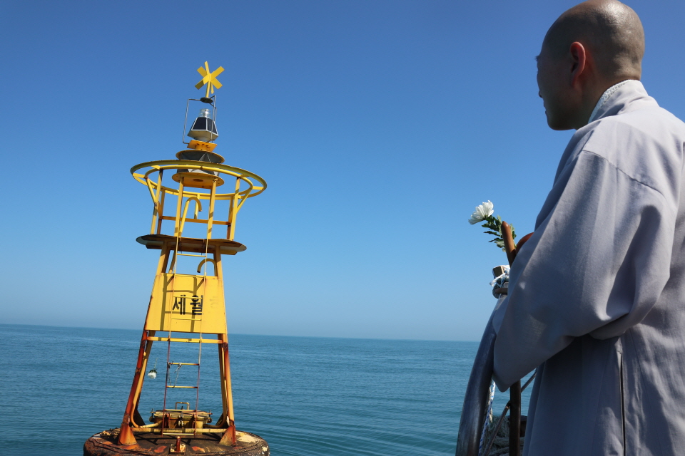 세월호 10주기를 사흘 앞둔 4월13일, 조계종 사노위가 세월호 침몰 해역에서 ‘미수습자 수습 발원 기도회’를 봉행했다. 서원스님이 사고 해역임을 표시하는 노란 부표를 바라보고 있다.